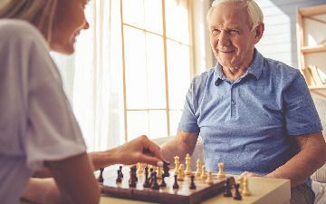 Older gentleman and woman playing chess