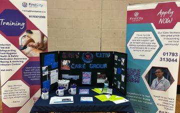 First City set up at a recruitment event, showing two roller banners and leaflets across a table
